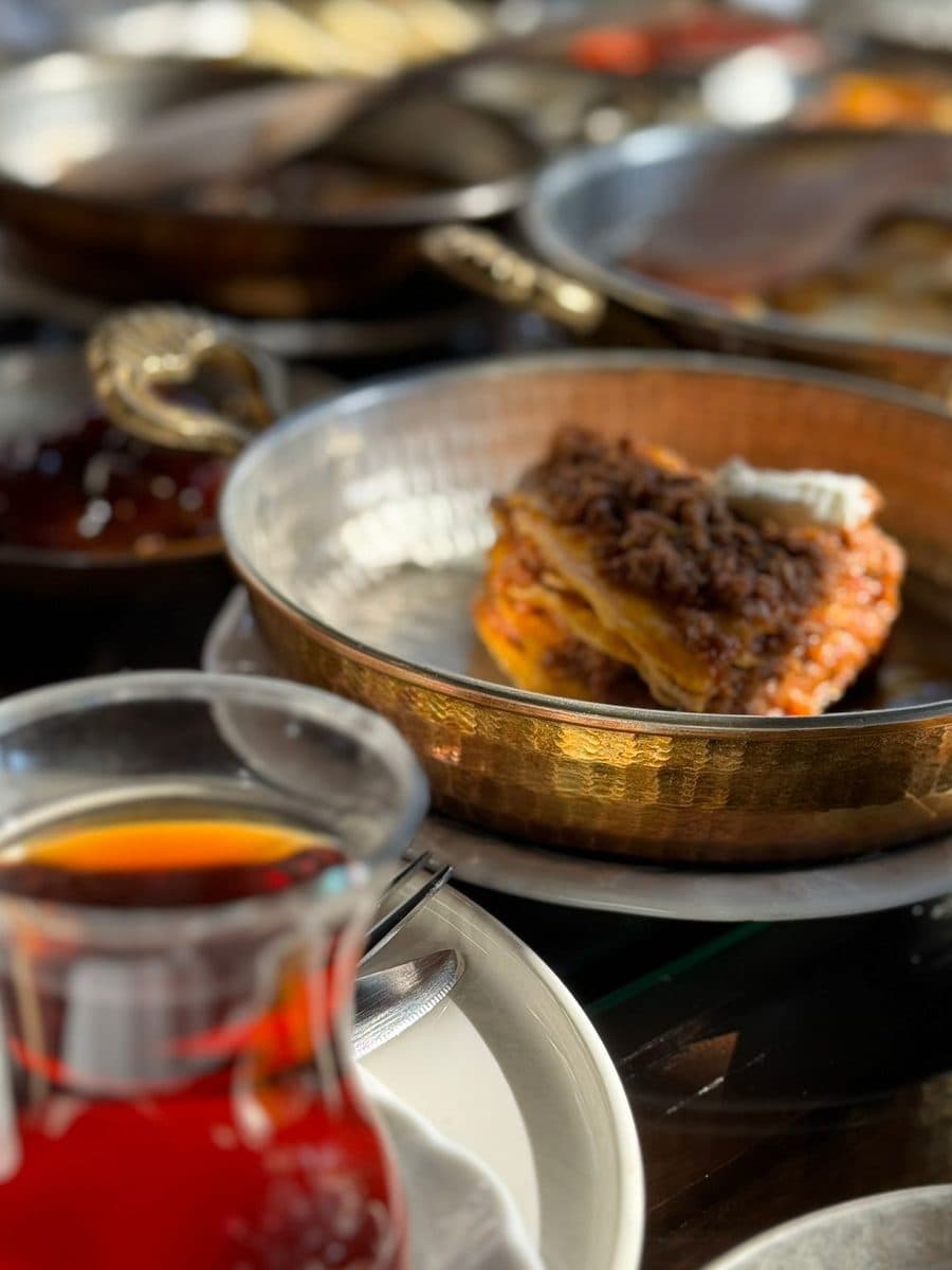 Bakır sahanda kavurmalı yumurta, yanında ince belli bardakta çay